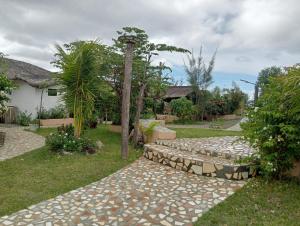a garden with a stone bench and a tree at Bregil Villas in Pagudpud