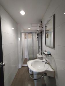 a white bathroom with a sink and a shower at Likas Square - KK Apartment Suite in Kota Kinabalu +32 photos