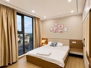 a bedroom with a bed and a large window at Beer's Homes Căn hộ chung cư Pearl Residence in Cửa Lô