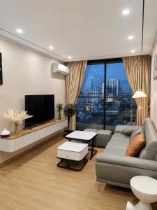 a living room with a couch and a tv at Beer's Homes Căn hộ chung cư Pearl Residence in Cửa Lô