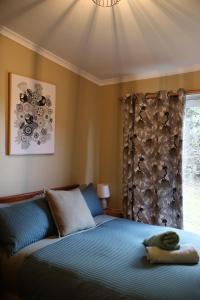 a bedroom with a blue bed with a window at Far View - Pets, Linen, Wi-Fi, Netflix, Caravan, EV in Venus Bay
