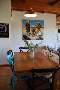 a wooden table with chairs and a painting on the wall at Far View - Pets, Linen, Wi-Fi, Netflix, Caravan, EV in Venus Bay
