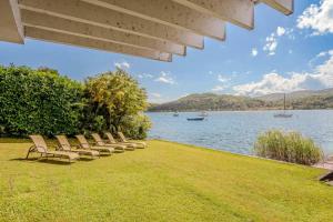 a row of chairs sitting next to a body of water at Ranco Villa - 14006 in Ranco