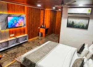 a bedroom with a bed and a tv on a wall at Rich Grand Hotel Near To Tajmahal in Agra