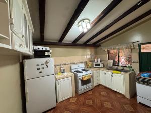 a kitchen with white appliances and wooden floors at MiniFinquita Ibarra in Ibarra +14 photos