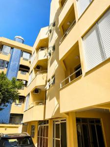 a building with a car parked in front of it at Casa Da Praia Apart Hotel in Florianópolis