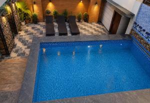 a swimming pool with chairs next to a building at Rich Grand Hotel Near To Tajmahal in Agra