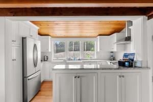 a kitchen with white cabinets and a wooden ceiling at Vista Mare in Rockport