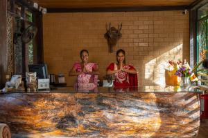 two women standing at the counter of a restaurant at Jungle Village Unawatuna in Unawatuna