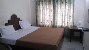 Postel nebo postele na pokoji v ubytování Luciya International Mysore
