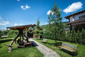 a park with a gazebo and two benches at Pensiunea Royal in Borşa