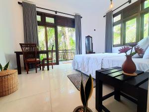 a bedroom with a bed and a table with a vase on it at Turtle Point Homestay - BB, Fast Wi-Fi, AC in Batigama