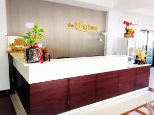 a counter in a restaurant with a sign on the wall at Baanthanthip in Khon Kaen