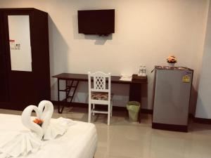 a bedroom with a desk and a bed with swans at Baanthanthip in Khon Kaen