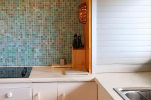 a kitchen with a sink and a blue tiled wall at Far View - Pets, Linen, Wi-Fi, Netflix, Caravan, EV in Venus Bay +30 photos