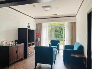 a living room with blue chairs and a large window at Tiantai Hotel in Wachangtan