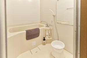 a white bathroom with a shower and a toilet at Green hills 102 in Kumamoto