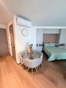 a bedroom with a table and a bed and a clock at Adamant Grand in Laurel de Lagunillas