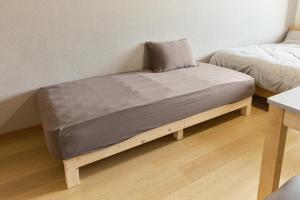a bed sitting on a wooden platform in a room at Green hills 102 in Kumamoto