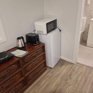 a kitchen with a microwave on top of a refrigerator at 2 Bedroom garden chalet in Rotorua +17 photos