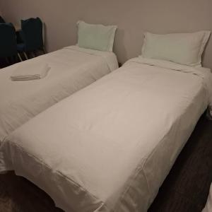 two beds sitting next to each other in a room at 2 Bedroom garden chalet in Rotorua