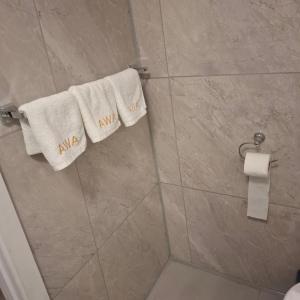 a bathroom with white towels on a shower stall at 2 Bedroom garden chalet in Rotorua
