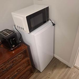 a microwave sitting on top of a refrigerator at 2 Bedroom garden chalet in Rotorua