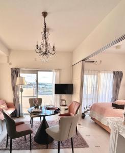 ein Schlafzimmer mit einem Bett, einem Tisch und Stühlen in der Unterkunft SunSea Okinawa Stunning Ocean View 2BR Sleeps 6 20 min from Airport 3 min to Shopping Mall in Urazoe