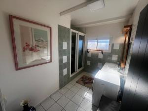 a bathroom with a sink and a window at La Caze Vital in Saint-Joseph