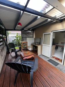 a patio with a table and chairs on a deck at La Caze Vital in Saint-Joseph +3 photos
