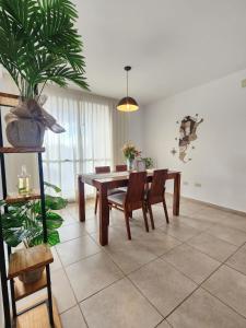 a dining room with a table and chairs and a plant at Bohemian dream in Ezeiza
