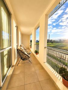 a balcony with a chair and large windows at Bohemian dream in Ezeiza