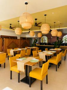 a restaurant with wooden tables and yellow chairs at Boracay Sands Hotel in Boracay