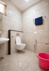 a bathroom with a toilet and a sink at Holapu Thayi Villa in Mysore