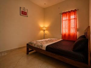 a bedroom with a bed and a red window at Holapu Thayi Villa in Mysore