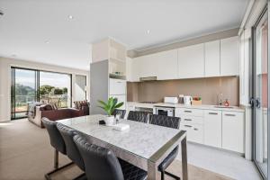 a kitchen and dining room with a table and chairs at Potters Hill Haven in San Remo