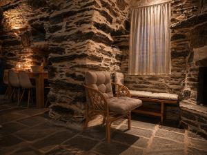a stone room with a chair and a window at Nostos Kea in Káto Meriá +4 photos