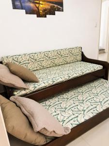 a bed with two pillows on top of it at Casa Da Praia Apart Hotel in Florianópolis