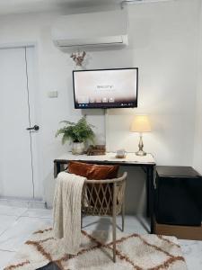 a room with a desk with a television on the wall at SET Inn-2 in Kata Beach
