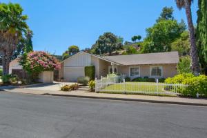 a house with a white fence on a street at NEW Relax & Explore from MissionViejo | Pool | Spa in Mission Viejo