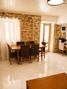 a dining room with a wooden table and chairs at Mikel's Village House in Káto Garoúna
