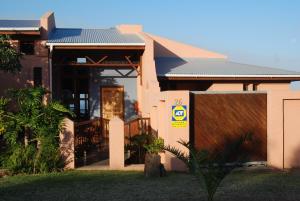 a house with a gate in front of it at The Gem sea facing free standing holiday house solar power in Jeffreys Bay