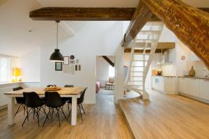 Il comprend une cuisine et une salle à manger avec une table et des chaises en bois. dans l'établissement "Karel de Grote" Bergen, à Bergen