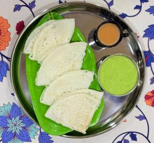 a plate of bread on a plate with green sauce at Shree Kelbai Homestay in Malvan +4 photos