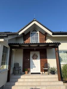 a front porch of a house with a white door at Apartment Hydrangea Home in Plavnica +3 photos