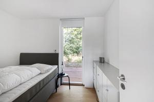 a bedroom with a bed and a dresser and a window at Holiday Home On Bornholm Close To Sea And Beach in Vester Sømarken