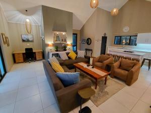 a large living room with couches and a table at Underwood Country Manor in Underberg