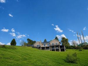 a large house on a hill with a green field at Underwood Country Manor in Underberg