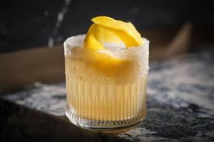 a drink with an orange peel on top of it at Kimpton El Castelar Polanco by IHG in Mexico City