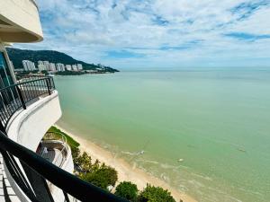 a view of the beach from a balcony of a building at Rainbow Paradise Seaview by Achlys Collection in Tanjung Bungah